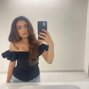 Svart offshoulder topp - Snygg svart offshoulder topp med volangdetaljer. Perfekt för en stilren och trendig look. Passar bra till både jeans och kjol. Frakt tillkommer/ kan mötas upp i Stockholm!