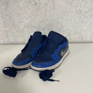  Air Jordans - Snygga blå Nike Air Jordans med klassisk design och grå swoosh. Skorna har snörning och rund tå, perfekt för en sportig look. De är tillverkade i syntetmaterial och har en bekväm passform. Otroligt fint skick då dom knappt är använda! Ny pris 1300kr. Mitt pris 299kr 