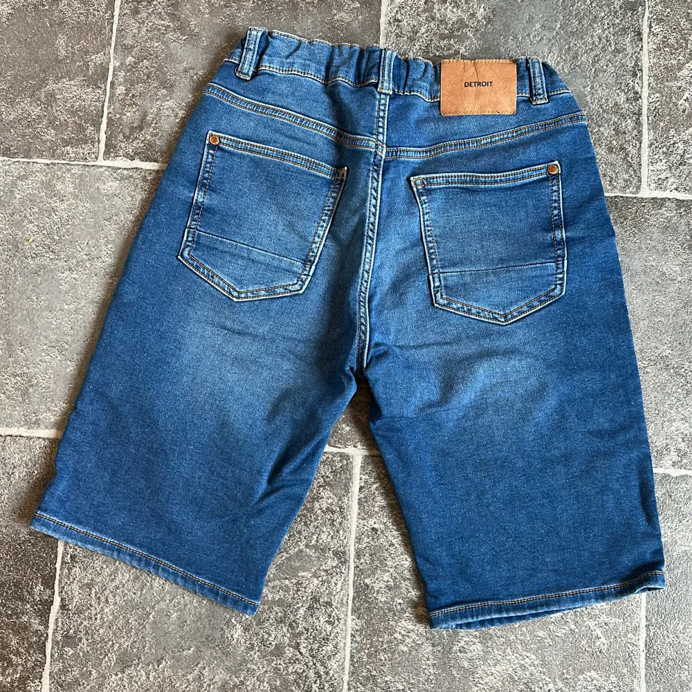 Säljer ett par snygga blå jeansshorts från Lindex med klassisk femficksdesign och en bekväm elastisk midja. Perfekta för sommarens alla äventyr! 🔥. Shortsit.