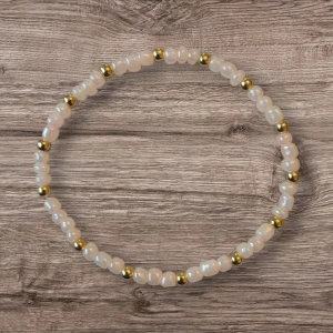 Pärlarmband med gulddetaljer - Elegant armband med ljusrosa pärlor och små guldfärgade detaljer. Perfekt för att ge en touch av stil till din outfit. Elastiskt band för enkel passform.