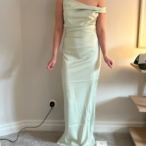 Ljusgrön långklänning från ADOORE - Almeria Maxi Dress - Light sage. Elegant ljusgrön långklänning från ADOORE med offshoulder-design. Klänningen har en smickrande passform och är perfekt för speciella tillfällen. Aldrig använd. Nypris 1595 kronor 