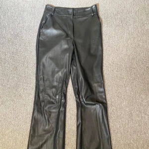 Svarta skinnbyxor - Snygga svarta skinnbyxor med hög midja och bootcut-stil. 