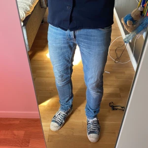 Nudie jeans-Grim Tim - Säljer ett par Nudie jeans i modellen Grim Tim. Storlek 30/32. Mycket bra skicka förutom ett hål i skrevet som fixades på Nudie affär. Hör av dig för frågor eller funderingar.
