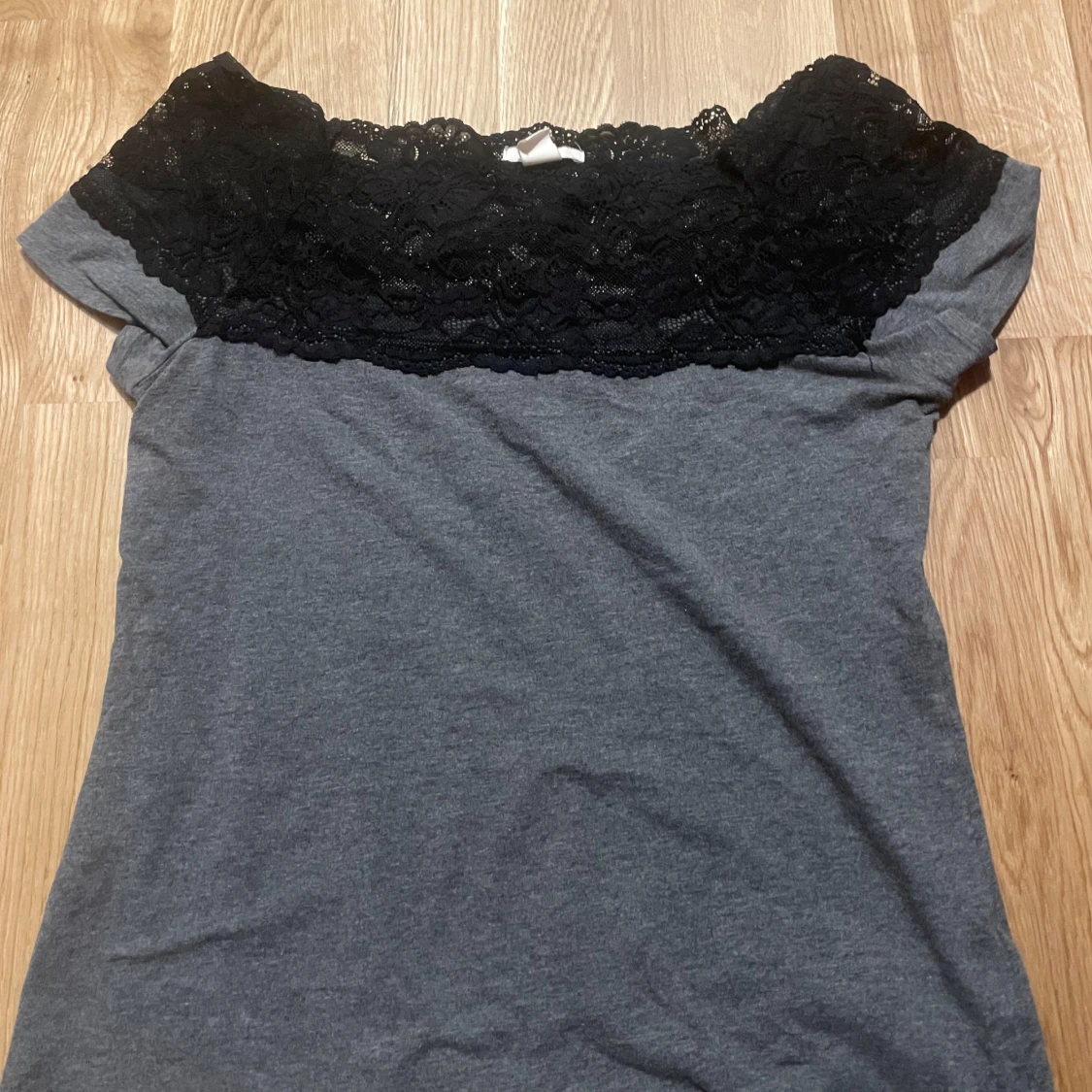 Grå topp med svart spetsdetalj