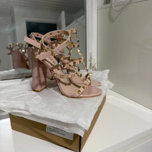 Beiga klackar med nitar  - Säljer ett par eleganta klackar med nitar och öppen tå. De har en hög klack och justerbara remmar för perfekt passform. 