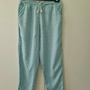Mönstrade mjukisbyxor - Turkosa mönstrade mjukisbyxor. Slutet av benen har det blivit slitet som man ser på bilderna. För barn