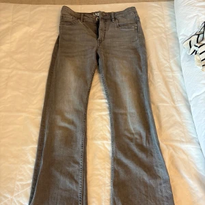 Grå jeans från LAB Industries, stl 158 - Snygga grå jeans från LAB Industries i rak modell med lite bootcut. Justerbar midja. Jeansen har en cool, lite tvättad look och är gjorda i mjukt bomullsmaterial med en touch av stretch för extra komfort. 