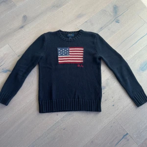 Mörkblå stickad tröja Polo Ralph Lauren - Hej!! Säljer nu en snygg mörkblå stickad tröja från Polo Ralph Lauren med amerikansk flagga i rött, vitt och blått på bröstet samt RL-broderi. Tröjan har rund hals, ribbade muddar och lång ärm. Perfekt för dig som gillar klassisk stil med en twist. Köpt i butik för ett tag sen, säljer pga av att den för liten. Varit favorit tröjan ett bra tag! Hör av dig vid minsta fundering eller fråga! Ha en bra dag mvh Leo! Ps pris ej hugget i sten