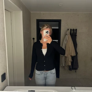 Svart kofta med guldfärgade knappar - Snygg svart finstickad kofta/cardigan med guldfärgade knappar framtill. Från Lindex storlek S knappast använd!