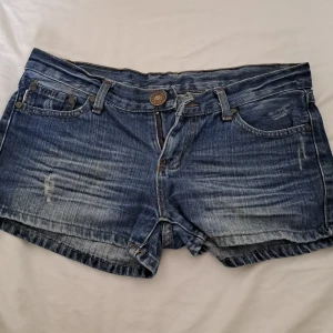 Mörkblåa basic jeansshorts low waist - Snygga basic jeansshorts med randiga detaljer. Köpt från en marknad i Thailand.
