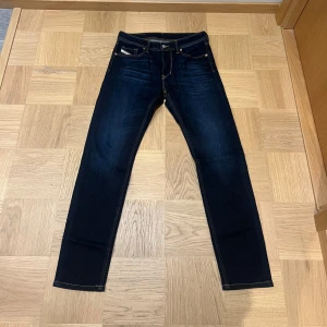 Mörkblå jeans från Diesel - Snygga mörkblå jeans från Diesel. Modellen är ganska slim med hyfsat smal passform och raka ben. Byxorna är i nyskick och ör använda någon enstaka gång. Storlek 29/32