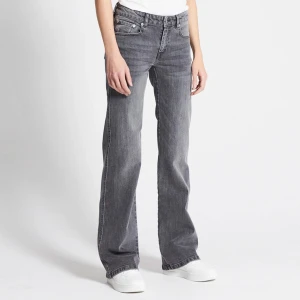 Lager 157 grå bootcut jeans - Snygga grå jeans från Lager 157 med bootcut passform och klassiska fem fickor. Jeansen har en mörkgrå ton, raka ben med lätt utsvängning och silverfärgade knappar. Perfekt för dig som gillar en avslappnad men trendig stil. I storlek xs short length