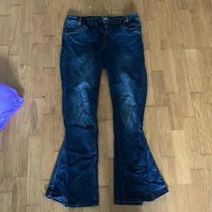 Bootcut jeans från Multiblu W40 L32 - Mörkblå bootcut jeans från Multiblu, omsydda så som blivit bootcut istället för straight. Mönsternpå fickorna med brunt, ett litet hål finns på vänster ben men det går att fixa fort. Tvättas och stryks innan jag skickar!☺️