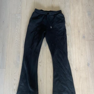 Svarta bootcut mjukisbyxor Mywear Woman - Svarta mjukisbyxor från Mywear Woman i storlek S. Byxorna har perfekta bootcut-ben och en bekväm midja med snörning. Perfekta för chill dagar och har en loose passform som ger skön vibe. Materialet är mjukt och stretchigt, vilket gör dem extra bekväma.