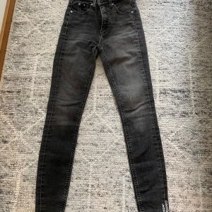 Svarta skinny jeans från Calvin Klein - Snygga svarta skinny jeans från Calvin Klein med klassisk femficksdesign och logotyp på både ficka och linning. Jeansen har hög midja, smal passform och dragkedja i gylfen. Materialet är stretchigt jeans för en bekväm känsla och cool look.