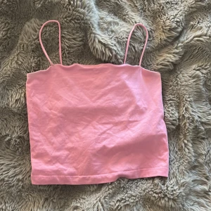 Rosa linnetopp från Gina Tricot - Supersöt ljusrosa linnetopp från Gina Tricot i storlek S. Toppen har smala axelband och är croppad med en enkel, rak form. Perfekt att styla med jeans eller kjol för en chill look. Materialet är mjuk bomull som känns skönt mot huden.