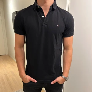  Tommy Hilfiger pike - En snygg svart piké från Tommy hilfiger i använt skick men inga defekter. Nypris ca 700kr. Hör av dig vid frågor eller funderingar 
