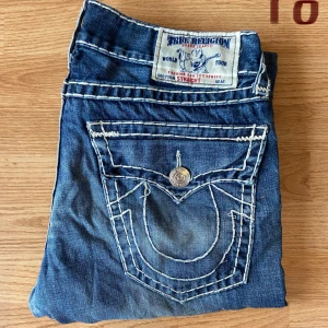True Religion Jeans Straight  - Feta true religion jeans, straight, storlek 34, bra skick, med slitningar, midja 43cm, längd 113cm, innerben 83cm och benöpppning 23cm.