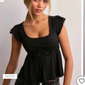Svart blus med volangärm och knyt - Supersöt svart blus med volangärmar och knyt under bysten från Nelly. Säljer då den inte kommer till användning. Väldigt bra skick den är i storlek xxs men jag har normalt xs och s och den passar mig💕