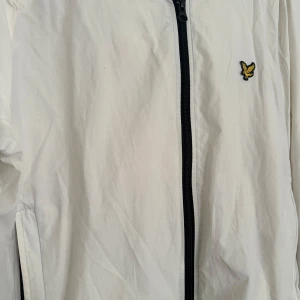 Vit vindjacka från Lyle & Scott - Snygg vit vindjacka från Lyle & Scott i storlek M. Jackan har svart dragkedja framtill, även en väldigt svår modell att få tag på. Jackan är använd men har inga skador osv och är i fint skick. Priset kan diskuteras vid snabbköp. 
