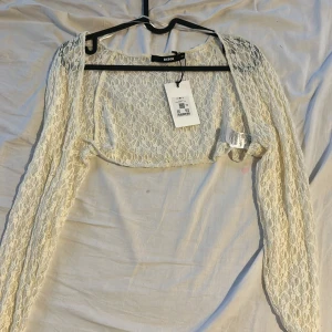 Vit spetsig bolerotopp från Bikbok - Säljer en superfin vit bolerotopp från Bikbok i storlek M. Helt oanvänd med prislapp kvar.