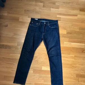 Levi's 502 mörkblå jeans 32/32, send offer, Skicka bud! - Säljer ett par Levi's 502 jeans i mörkblå tvätt med klassisk femficksdesign och snygga kontrastsömmar. Modellen har rak passform och normal midja, tillverkad i slitstarkt bomullsjeansmaterial. Perfekt för dig som gillar tidlös stil och vill ha ett par jeans som funkar till allt.