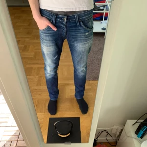 Blå jeans med slitningar och fade - Ett par blå jeans från Jack and Jones med snygga slitningar och fade. Jeansen är i mycket bra skick.