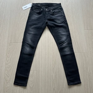 Svarta jeans från Dondup  - Snygga svarta jeans från Dondup med en modern slim passform. De har en klassisk femficksdesign och stängs med knappar. Perfekta för en stilren look. De är modellen George och dessa är näst intill nya , tyvärr för små för mig. Dom är i storlek 31 men passar nog en 32 också🙌🏼