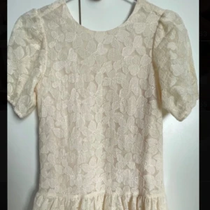 Vit spetsklänning med blommönster från Name It - Söt vit klänning från Name It med kort puffärm. Endast använd på en skolavslutning. Nypris 700kr 💕