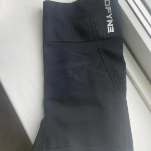 Svarta seamless shorts  - Svarta seamless shorts med hög midja och ribbad linning. Tight passform och stretchigt material som passar perfekt för träning. Diskret logga framtill i vitt. (Obs inget märke bak bara fram)