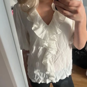 Vit blus med volang och v-ringning - Säljer en söt vit blus💞 