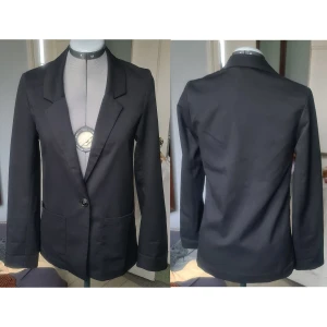 Kavaj/blazer svart 34 - Fint skick, lös tråd under ena fickan. 80% polyester, 18% viskos, 2% elastan. Foder 100% polyester. Lös passform, är mer som 36-38. Materialet ger den lite fall, den är rätt tunn och följsam.