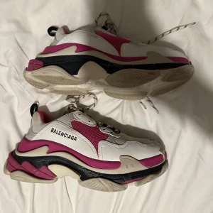 Balenciaga Triple S sneakers i vitt och rosa - Säljer ett par Balenciaga Triple S sneakers i vitt, rosa och svart. Skorna har chunky sula, snörning och tydlig logga på sidan. Kombinationen av mesh och läder ger en sportig och trendig look. Säljs pga att jag inte använder det. Används max 5 gr totalt, så fåtal gånger. Har inget kvitto eller paket till dem men kan autentiskt bevisat med hjälp av artikelnummer på skorna. Pris kan diskuteras vid snabb affär. 
