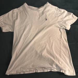 Vit t-shirt från Polo Ralph Lauren - Klassisk vit t-shirt från Polo Ralph Lauren med broderad marinblå logga på bröstet. T-shirten har rund halsringning och korta ärmar. Perfekt basplagg med stilren design.