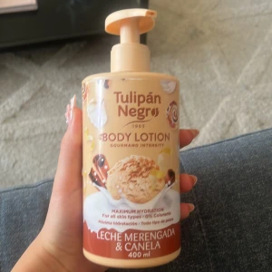 Tulipán Negro Body Lotion Leche Merengada & Canela - Body lotion med doft av leche merengada och kanel. Kommer i en beige plastflaska med pump och rymmer 400 ml. Ger intensiv återfuktning och passar alla hudtyper. Söt och kryddig doft, perfekt för dig som gillar gourmand-toner.