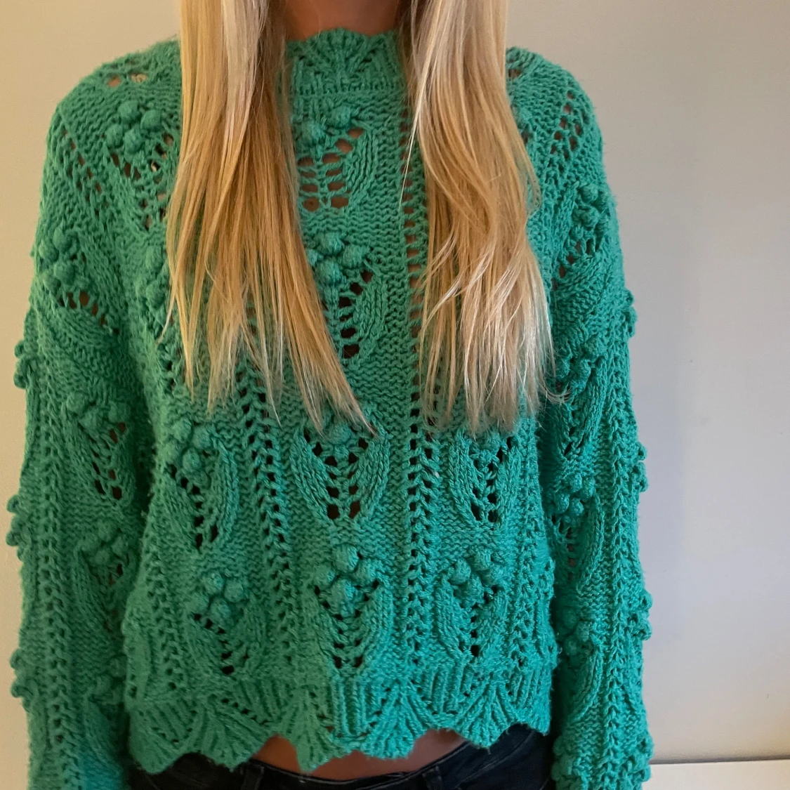 Grön stickad tröja med virkat mönster