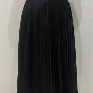 Svart medellång kjol från NAKD med resor i midjan, fin knappt anvönd kjol