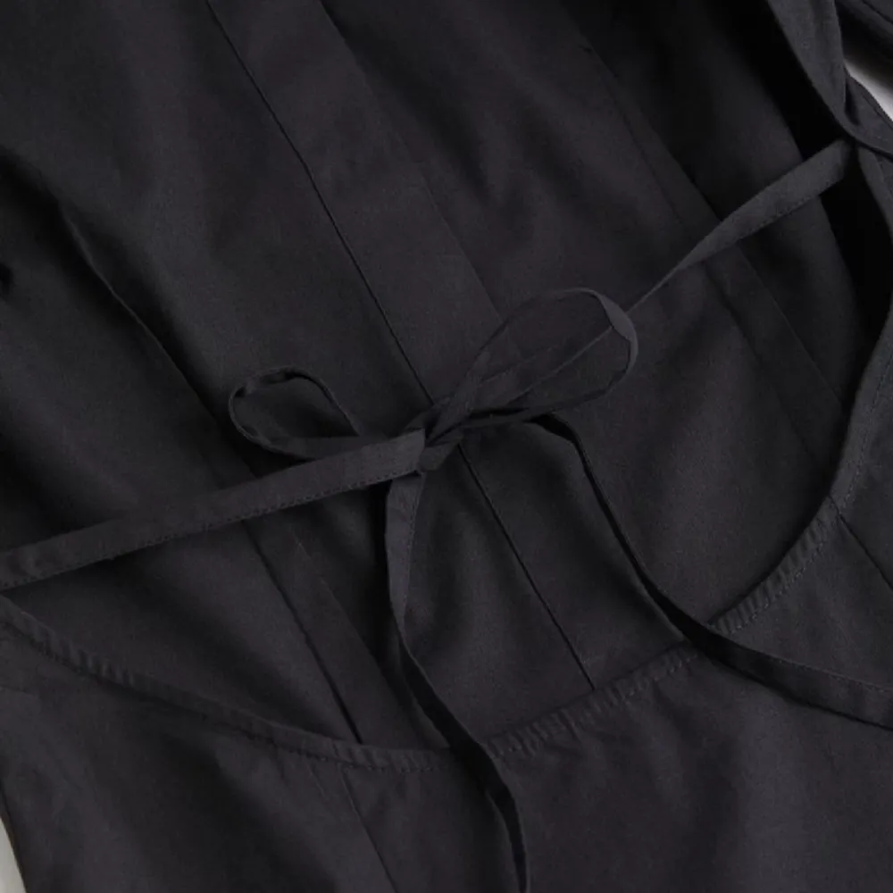 En svart skjorta från H&M med öppen rygg. Använd endast 1 gång.  Den sitter tight i midjan då det finns ett snöre man knyter i ryggen.. Skjortor.