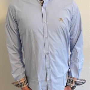 Burberry Skjorta - Ljus Blå - En riktigt snygg Burberry skjorta i färgen ljus blå i storlek M skicket är 9/10 och har inget tecken på att vara sönder. Ny pris på skjortan är ungefär 5200kr och vi säljer den för 800kr. Priset kan diskuteras vid snabb affär. Hör av er vid frågor 🥂