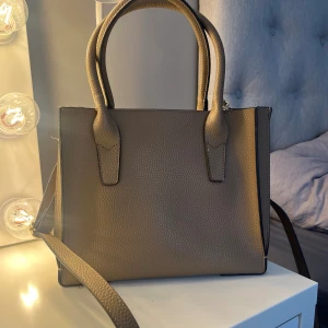 Väska  - Brun väska med guld detaljer som jag köpte från sellpy därav vet jag ej märke. Har själv aldrig använt den. 