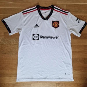 Manchester United Fotbollströja 22/23 - Säljer denna fotbollströja i storlek L. Varan är i gott skick och sparsamt använd. Smått uppriven på armen. Hör gärna av er vid fler frågor:)
