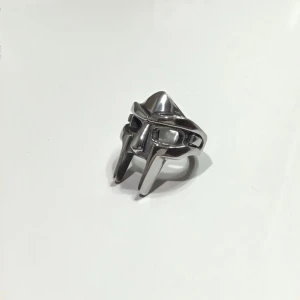 MF DOOM ring - Säljer en oanvänd MF doom ring då jag råkade beställa två och kan inte lämna tillbaks eftersom de är beställda från USA.  Den är alltså helt oanvänd och är fortfarande kvar i paketet :) Ställ frågor om ni har några. Jag köpte ringen för 250kr 