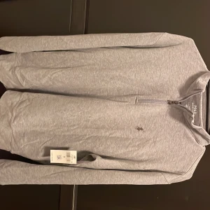 Ralph Lauren half zip - Grå Ralph Lauren half zip säljes Perfekt skick då den aldrig är använd pga för stor, prislapp finns kvar och säljes då den är köpt i USA och kan därmed ej returnera den. Storlek M 