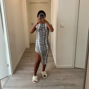 Klänning - Ganska hög slits på klänningen. Orm mönster på den. Använd endast en gång och köpt på boohoo. Det står UK 8 på storleken som motsvarar M men jag har XS/S och den passar mig. 