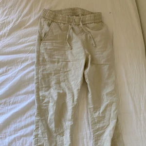 Linnebyxor - Beigea linnebyxor med snören. Kan prutas lite