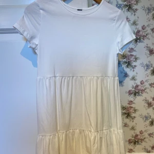 Vit klänning - Vit ”t-shirt”-klänning som är helt oanvänd.