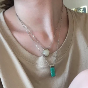 Halsband med vin och grön sten - Ett halsband med två snören i ett, två stenar. En grön en vit . Halsbandet aldrig använt 
