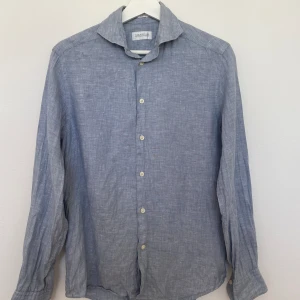 Ljusblå linneskjorta  - Ljusblå linneskjorta från These Glory Days, gott skick.