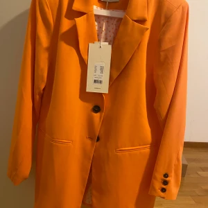 Fin orange kavaj - Köpt men aldrig använd orange kavaj,den är rätt så tun och sitter jätte fint på 