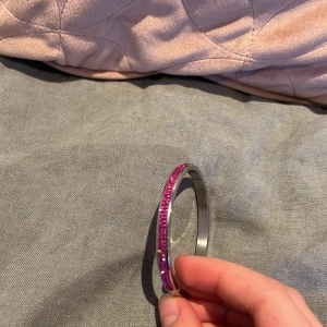 Två armband i silver - Ett lite större och ett lite mindre. Båda är i silver men den ena har lite glitter rosa på sig. Nästan aldrig använda och inga repor.